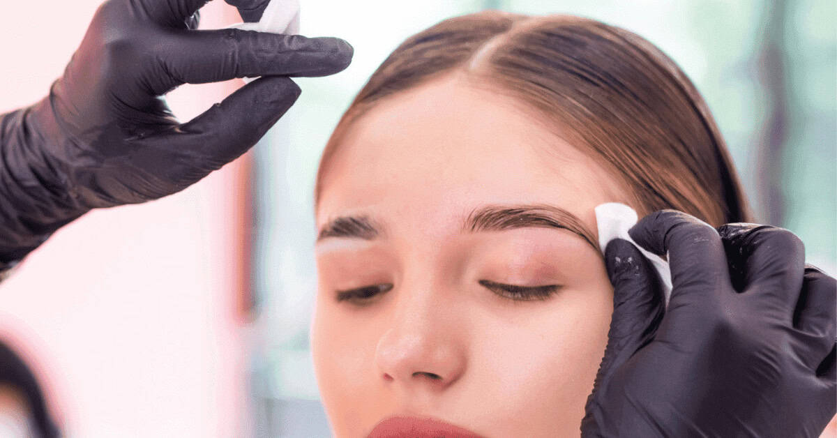 Soft, well-groomed eyebrows being prepped for makeup application with a cotton pad, emphasizing beauty and eye makeup enhancement.