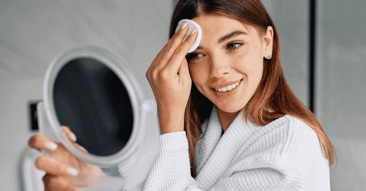 Flawless eye makeup woman applying mascara with cotton pad, beauty and skincare routine, close-up of eye makeup, natural smile, youthful skin, beauty tips.