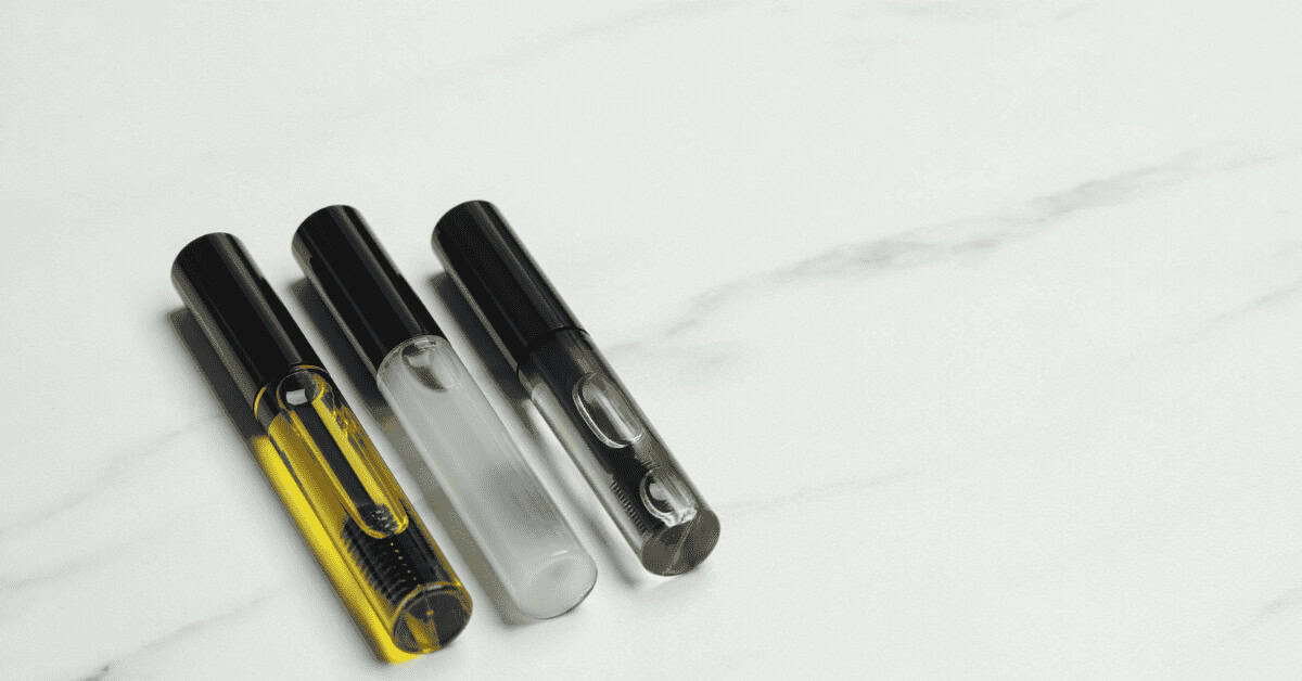 Vape pen collection with black caps, transparent bodies, and sleek design on a white marble surface, perfect for beauty and makeup enthusiasts.